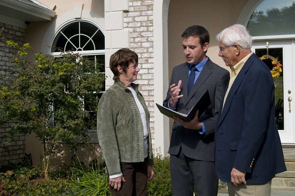 couple with real estate agent outside of home