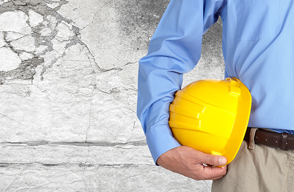 Person with construction helmet in cracked basement