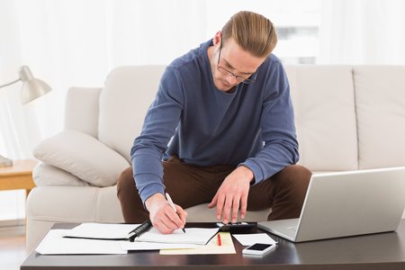 young man doing work in living room