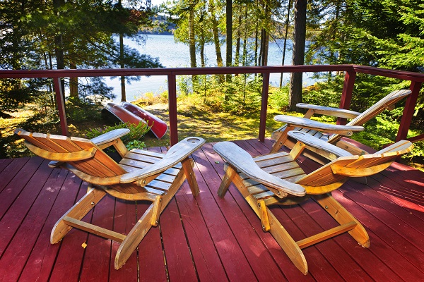adirondack chairs on deck by lake