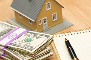 House surrounded by money and paperwork