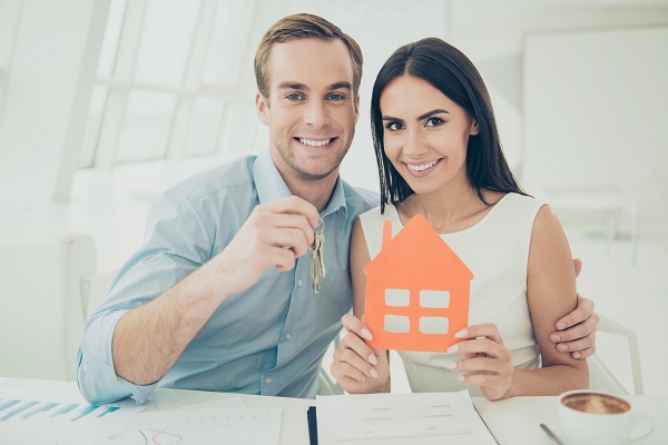 couple holding cut out of house