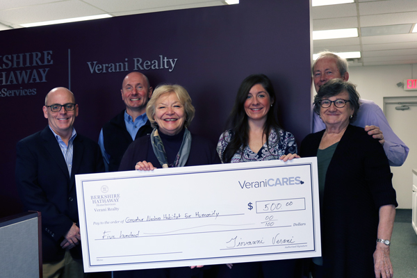 Verani agents holding big check